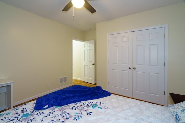 bedroom featuring baseboards, visible vents, a ceiling fan, and a closet