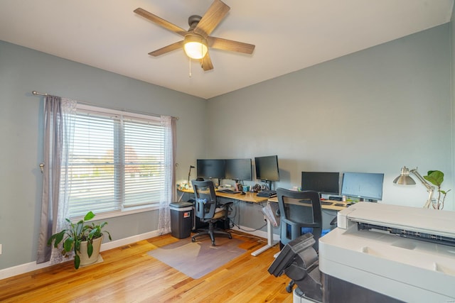 office featuring baseboards, a ceiling fan, and light wood-style floors