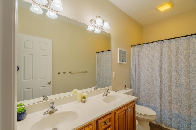 full bathroom featuring toilet, double vanity, and a sink