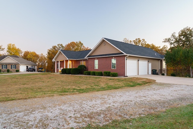 single story home featuring concrete driveway, brick siding, a front lawn, and a garage