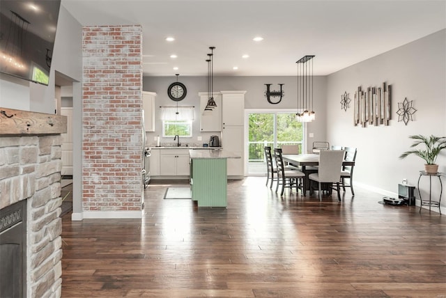 dining area with dark wood-type flooring, recessed lighting, baseboards, and a fireplace