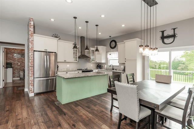 kitchen featuring a kitchen island, range with electric cooktop, a sink, freestanding refrigerator, and wall chimney exhaust hood