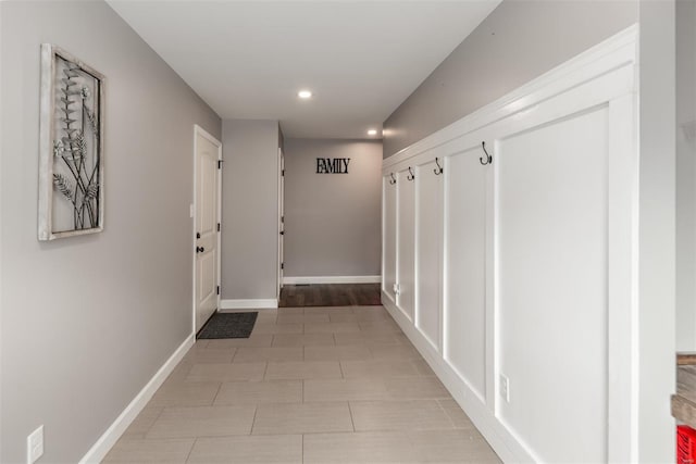 corridor featuring baseboards, recessed lighting, and light tile patterned flooring
