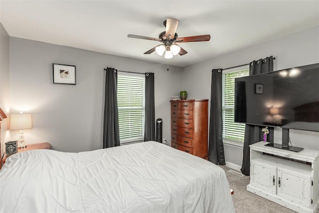 bedroom with baseboards, a ceiling fan, and light carpet