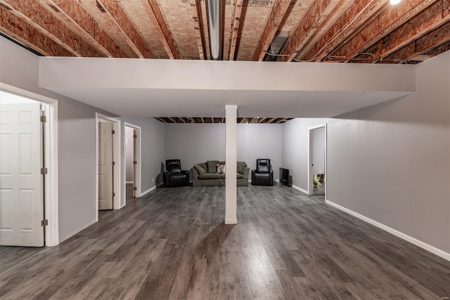 finished below grade area with baseboards and dark wood-style floors