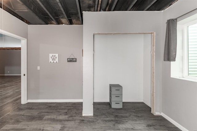 interior space featuring baseboards, a wealth of natural light, and wood finished floors