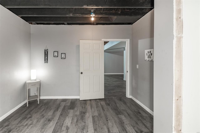 spare room featuring baseboards and wood finished floors