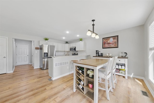 dining room with baseboards, recessed lighting, light wood-style flooring, and visible vents