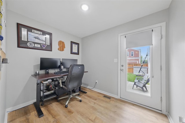 home office with light wood-type flooring and baseboards