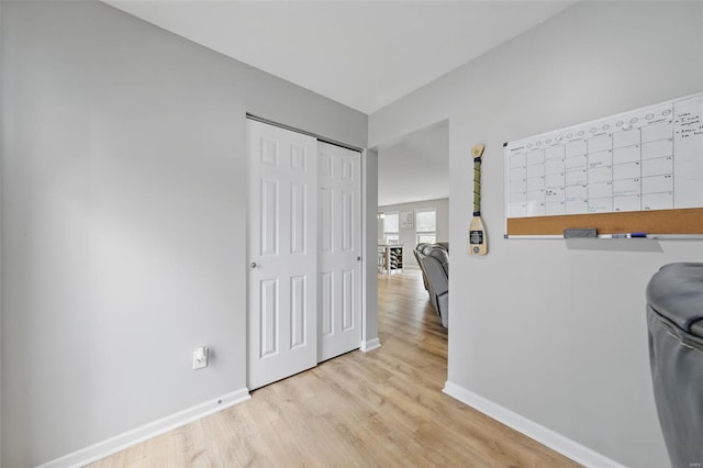 hallway featuring baseboards and wood finished floors