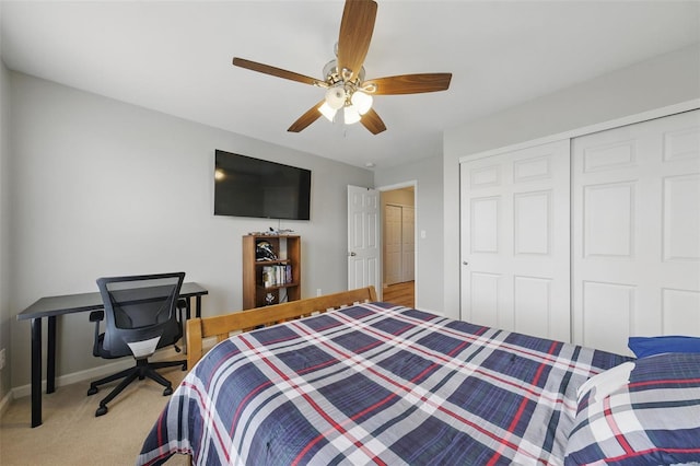 bedroom with baseboards, a ceiling fan, a closet, and light colored carpet