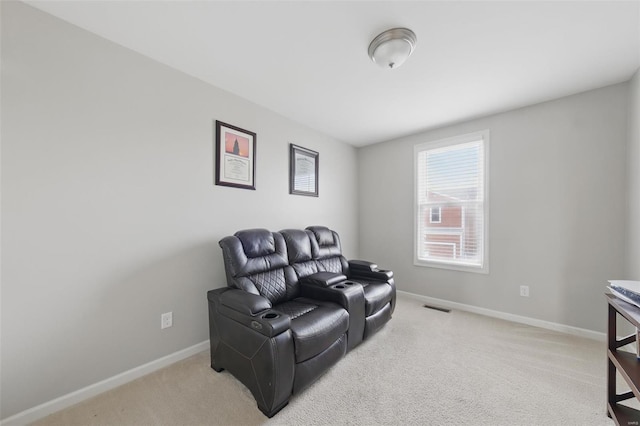 living area featuring baseboards, visible vents, and light carpet