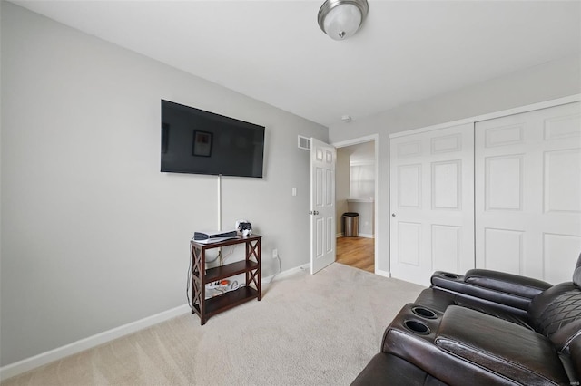 carpeted living area featuring baseboards