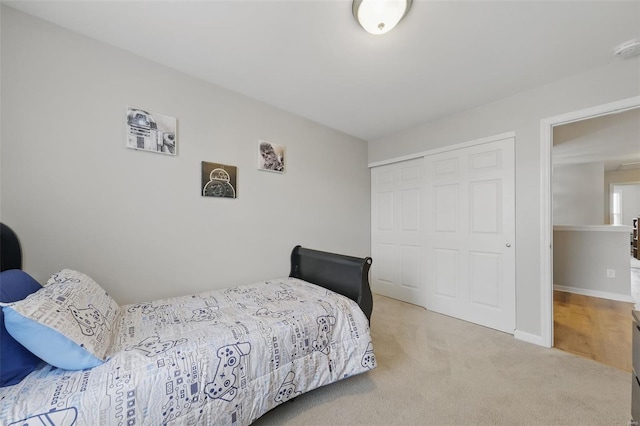 carpeted bedroom featuring a closet and baseboards