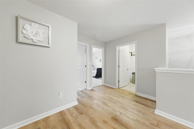 empty room featuring baseboards and light wood finished floors