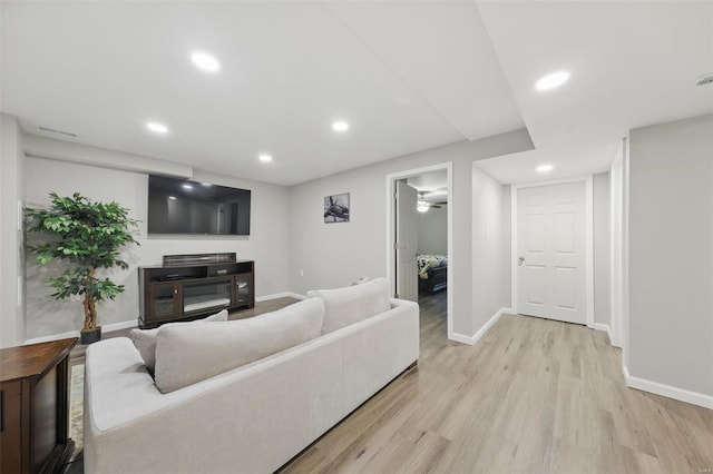living room featuring baseboards, recessed lighting, and light wood-style flooring