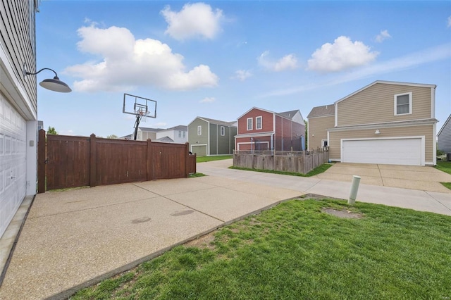 view of basketball court with a yard, fence, and a residential view