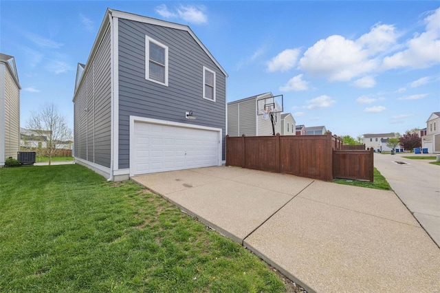 view of side of home featuring central air condition unit, fence, a yard, an attached garage, and concrete driveway