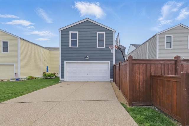 rear view of house with a yard, fence, and a garage