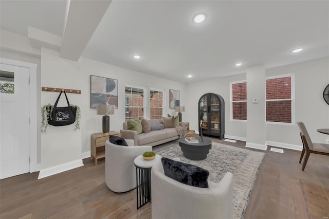 living area featuring dark wood-style flooring, a wealth of natural light, recessed lighting, and baseboards
