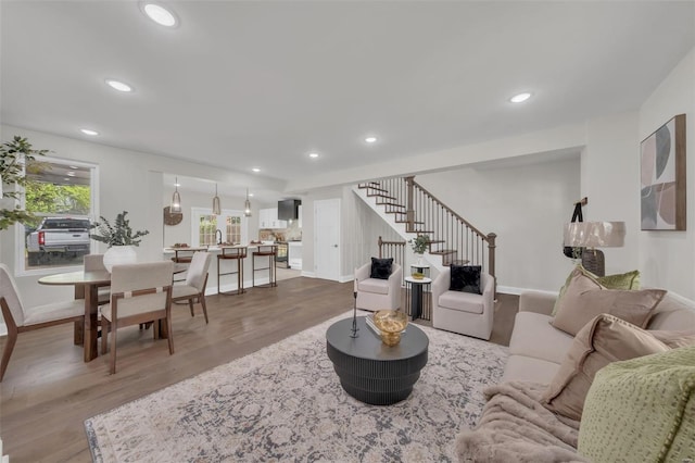 living room with recessed lighting, wood finished floors, and stairs