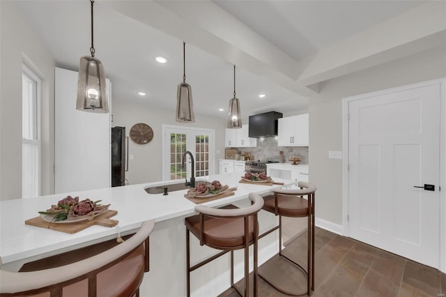 kitchen with a sink, decorative backsplash, stainless steel electric range, a breakfast bar, and light countertops