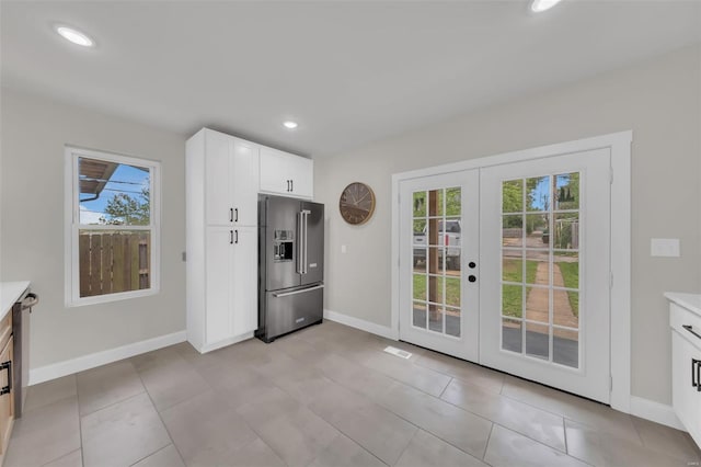 kitchen with a wealth of natural light, high end fridge, french doors, and baseboards