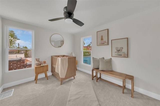 sitting room with baseboards, visible vents, and light carpet