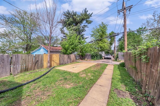 view of yard featuring driveway and a fenced backyard