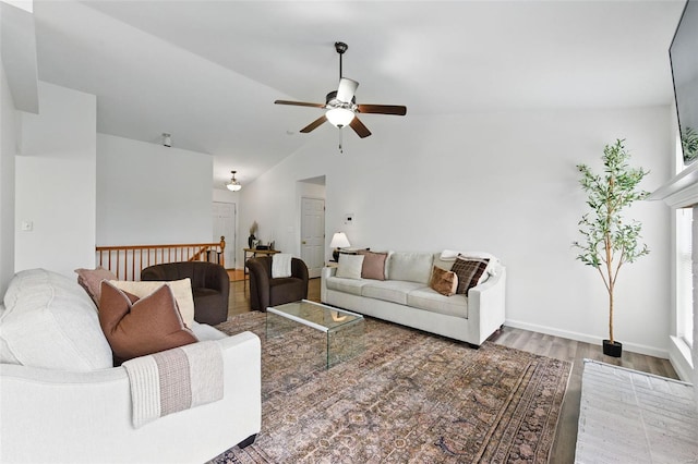 living room featuring baseboards, ceiling fan, vaulted ceiling, and wood finished floors