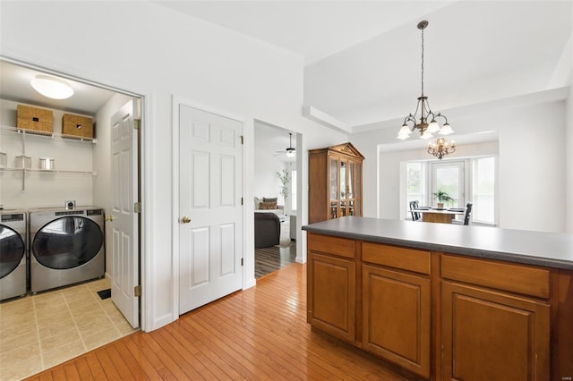 kitchen featuring brown cabinetry, light wood-type flooring, and washer and clothes dryer