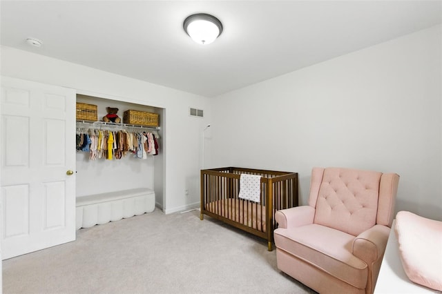 bedroom featuring visible vents, a crib, carpet floors, and a closet