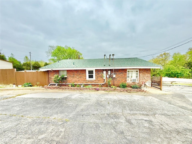 single story home featuring brick siding and fence