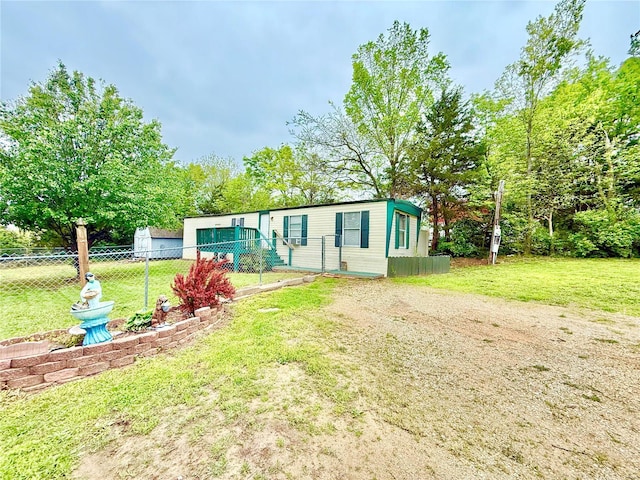 manufactured / mobile home featuring fence and a front lawn