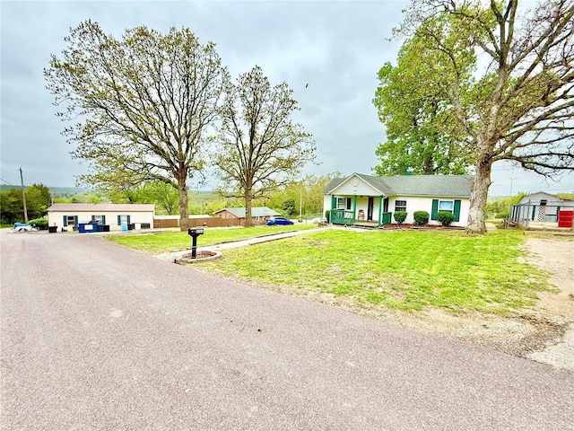 view of front of property featuring covered porch, fence, and a front lawn