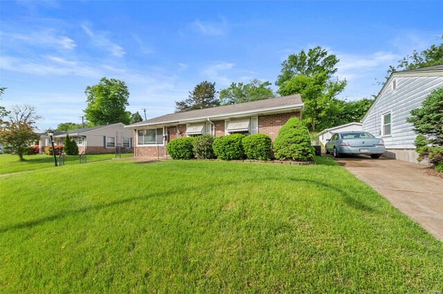 ranch-style house featuring brick siding, driveway, and a front lawn