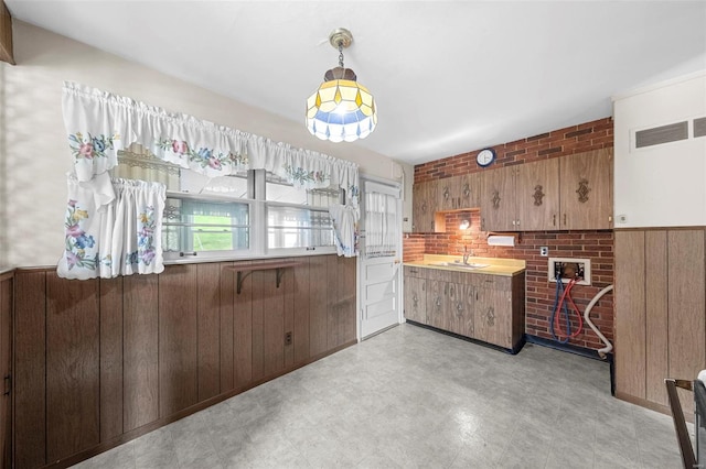 interior space featuring wooden walls, visible vents, a sink, and light floors