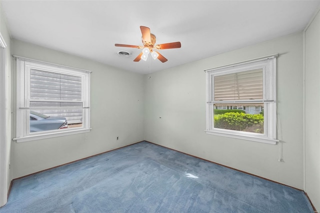 empty room with visible vents, a ceiling fan, and carpet floors