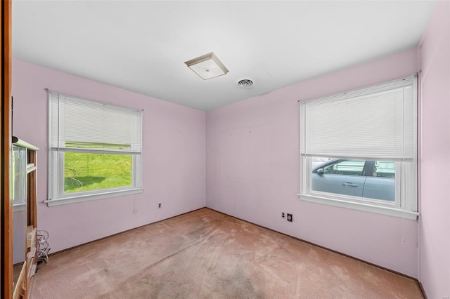 carpeted spare room featuring visible vents