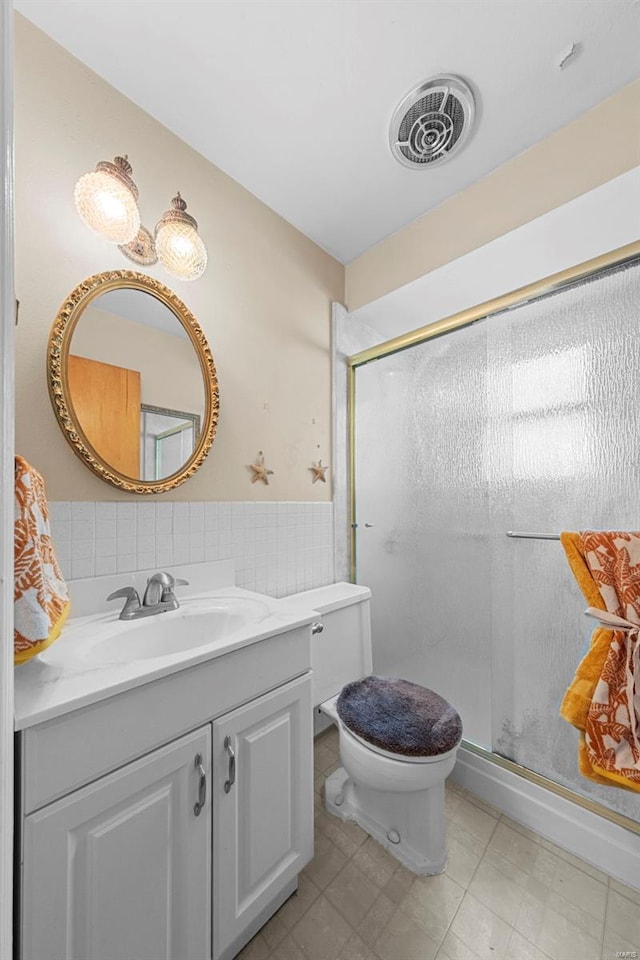 full bathroom with vanity, visible vents, wainscoting, toilet, and a stall shower