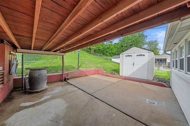 view of patio / terrace featuring a storage shed, fence, and an outdoor structure