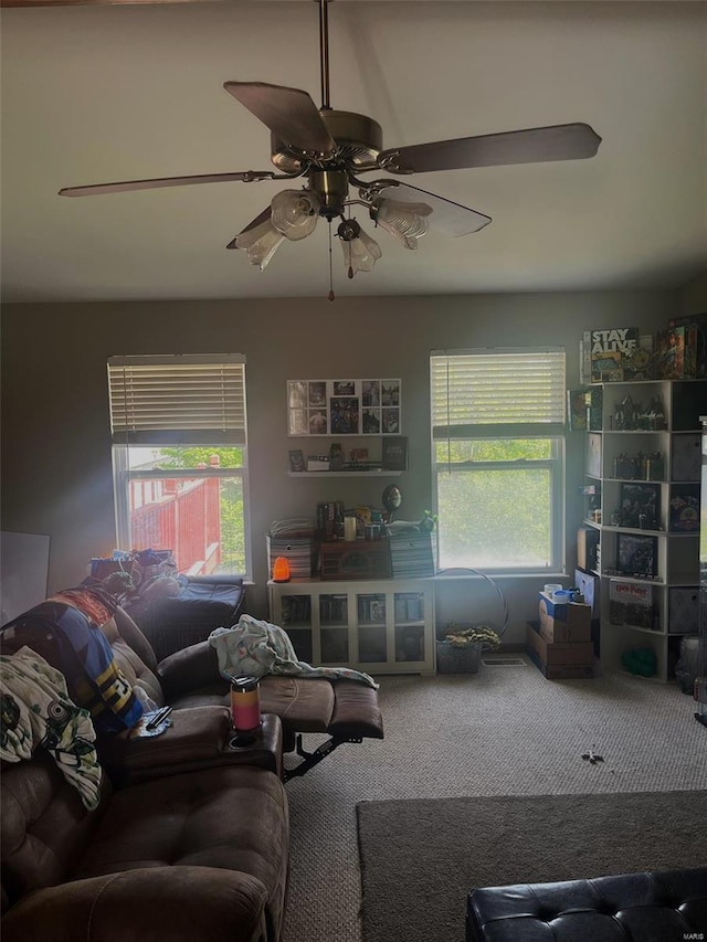 living area with a ceiling fan, carpet, and a healthy amount of sunlight