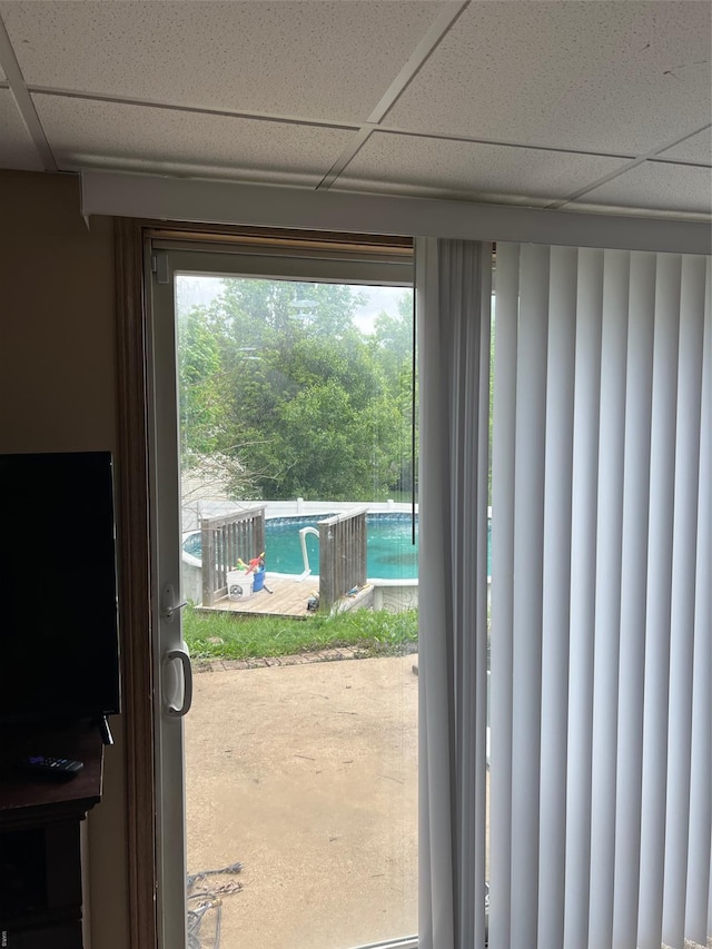 doorway to outside with a paneled ceiling