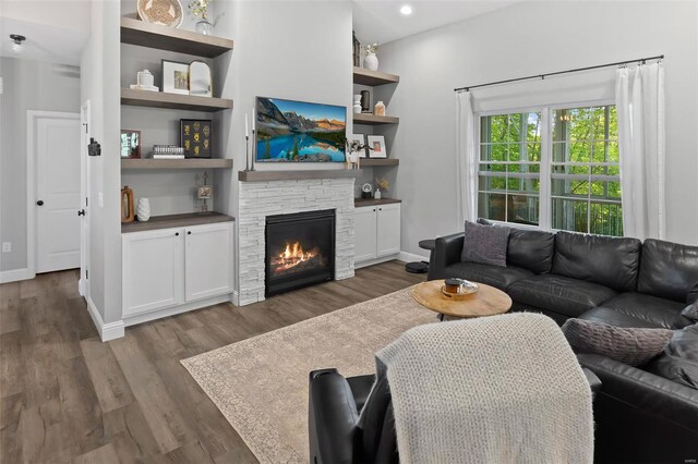 living room featuring dark wood-style flooring, baseboards, recessed lighting, and a fireplace