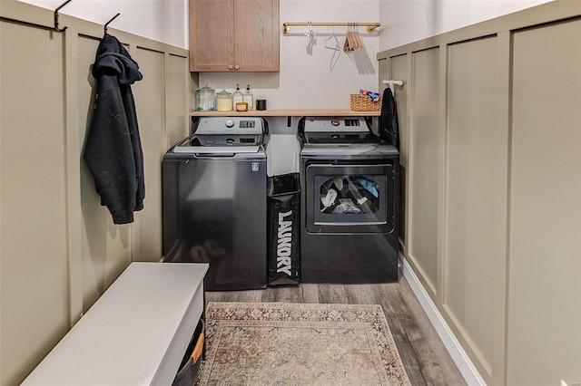 laundry room with dark wood-type flooring, cabinet space, and washer and dryer