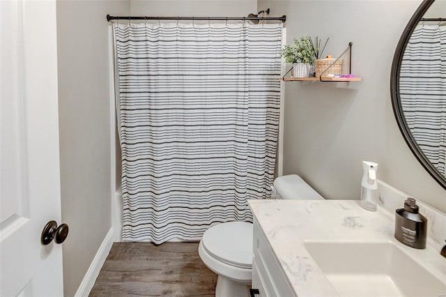 bathroom featuring a shower with shower curtain, toilet, wood finished floors, and vanity