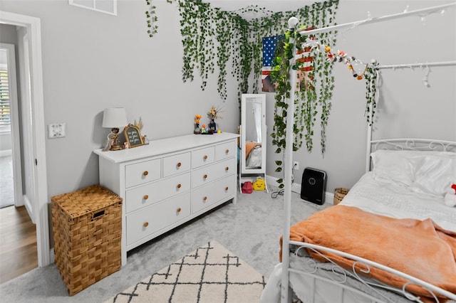 bedroom featuring visible vents and light carpet