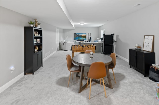 dining space featuring baseboards, light carpet, and visible vents