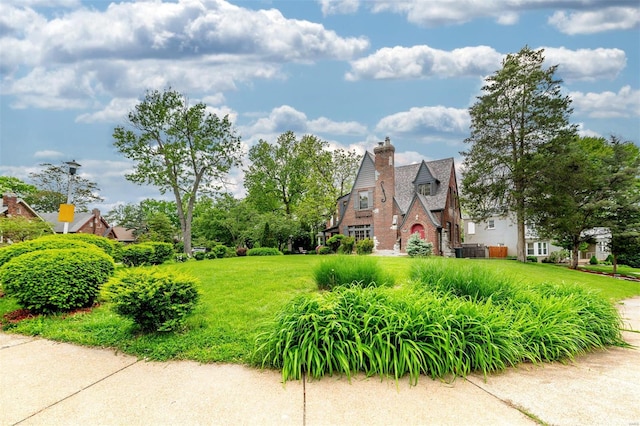 view of side of property featuring a chimney and a yard
