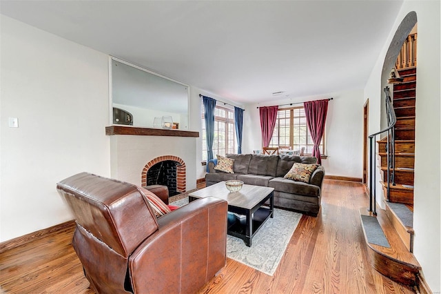 living room featuring a fireplace, wood finished floors, and baseboards